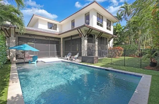 a view of a house with backyard and sitting area