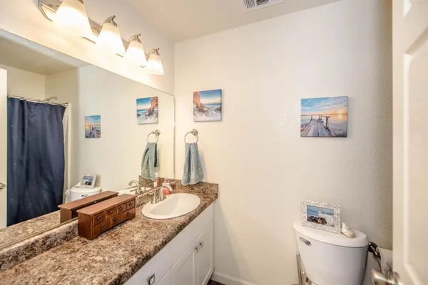 a bathroom with a granite countertop sink and a mirror