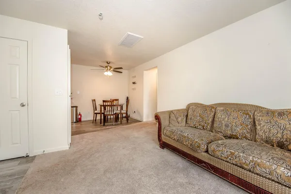 a living room with furniture and a dining table