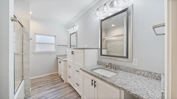 a bathroom with a granite countertop sink mirror and double