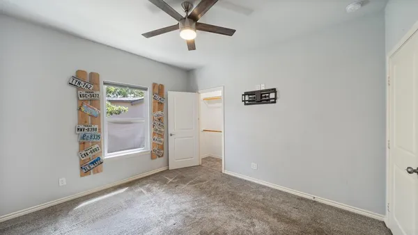 an empty room with windows and ceiling fan