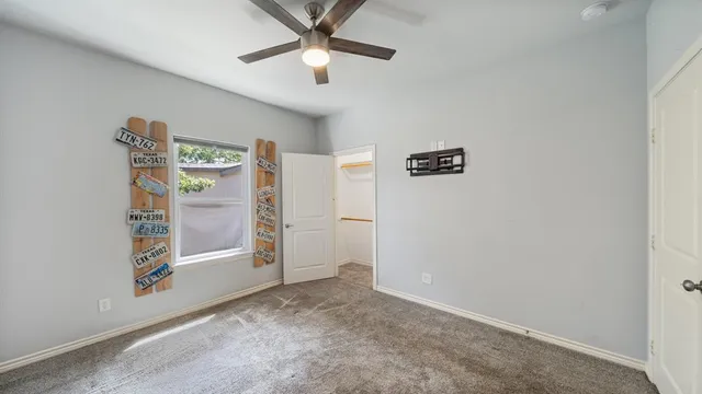 an empty room with windows and ceiling fan
