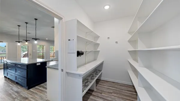 a living room with stainless steel appliances kitchen island granite countertop furniture and a wooden floor