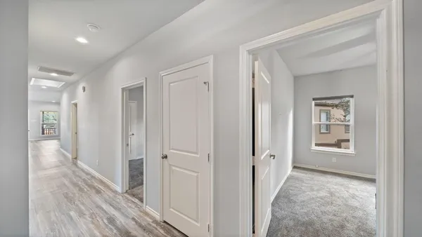 a view of a hallway with wooden floor and closet