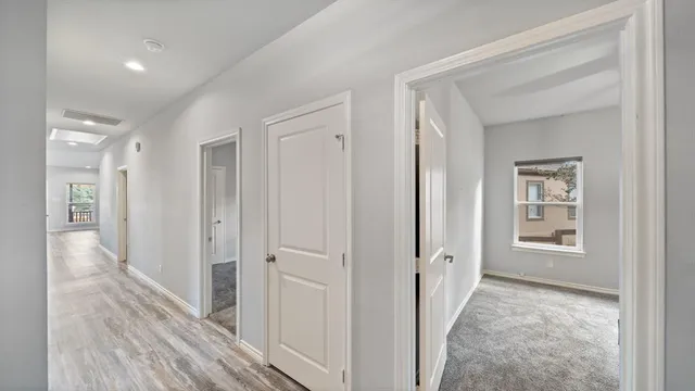 a view of a hallway with wooden floor and closet