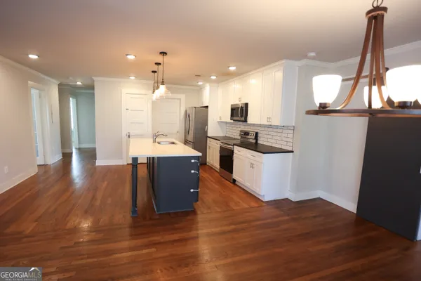 a kitchen with a sink a counter space and wooden floor