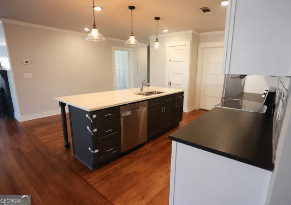 a large kitchen with a table chairs refrigerator and a stove