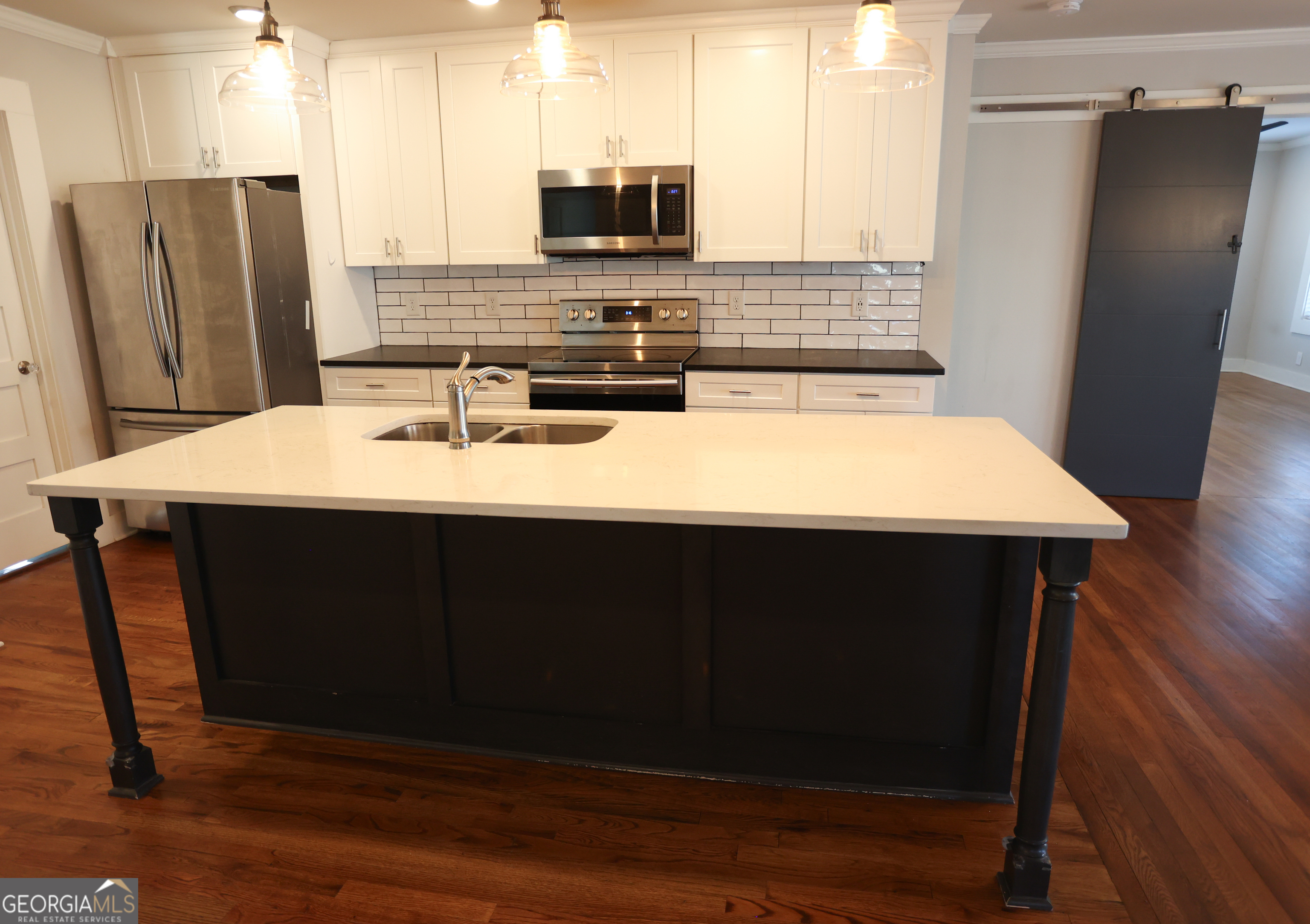68 Hayes Street Toccoa, GA 30577 - Photo 30 of 33 a kitchen with stainless steel appliances wooden floor sink refrigerator and microwave