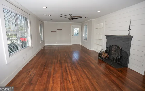 a view of empty room with wooden floor and fireplace