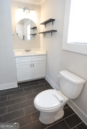 a bathroom with a toilet a sink and mirror