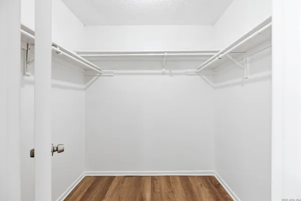 a view of walk in closet with empty racks