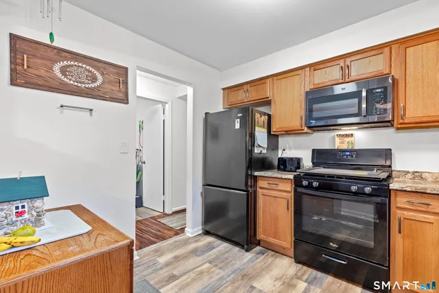 a kitchen with a refrigerator stove and wooden cabinets