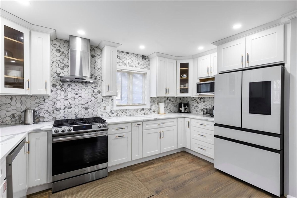 77 Cedar Street Boston, MA 02119 - Photo 8 of 25 a kitchen with white cabinets and stainless steel appliances