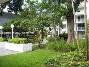 492 Northwest 165th Street, Unit C510 Miami, FL 33169 - Photo 8 of 9 a view of a garden with plants and large trees