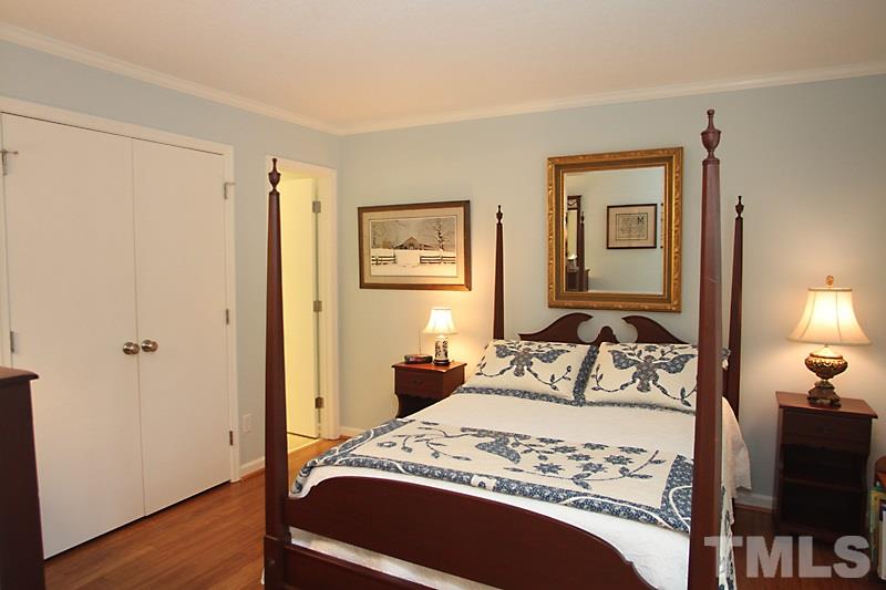 3405 Mill Run Raleigh, NC 27612 - Photo 8 of 12 a bedroom with a bed and wooden floor