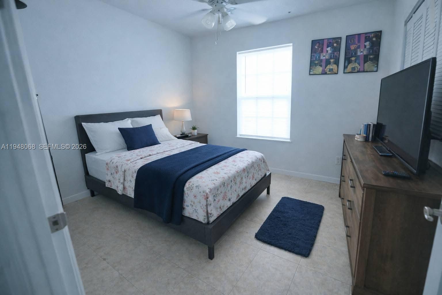 2145 Northwest 68th Terrace Miami, FL 33147 - Photo 4 of 12 a bedroom with a bed flat screen tv and a window