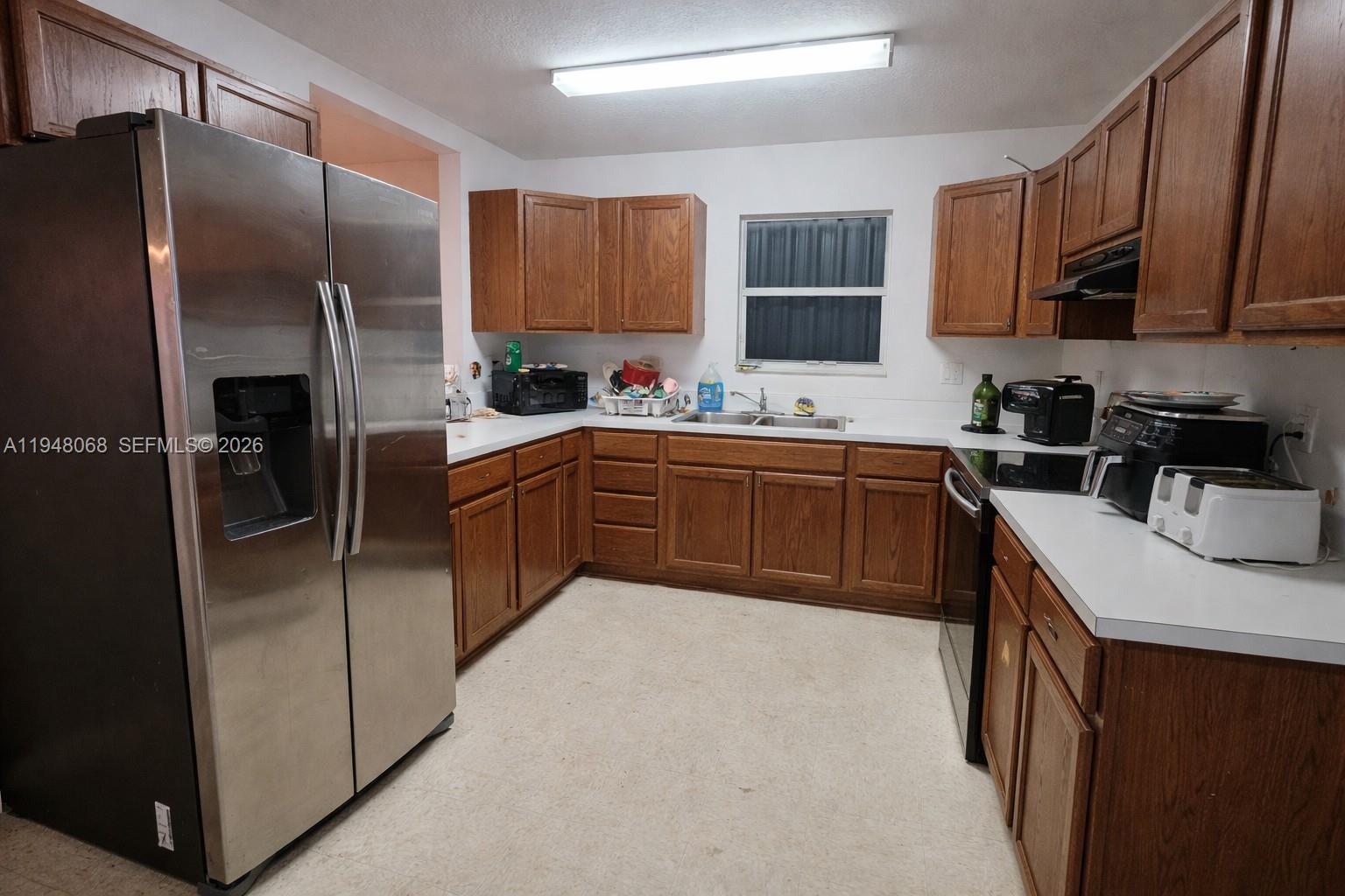 2145 Northwest 68th Terrace Miami, FL 33147 - Photo 7 of 12 a kitchen with stainless steel appliances granite countertop a sink stove refrigerator and cabinets