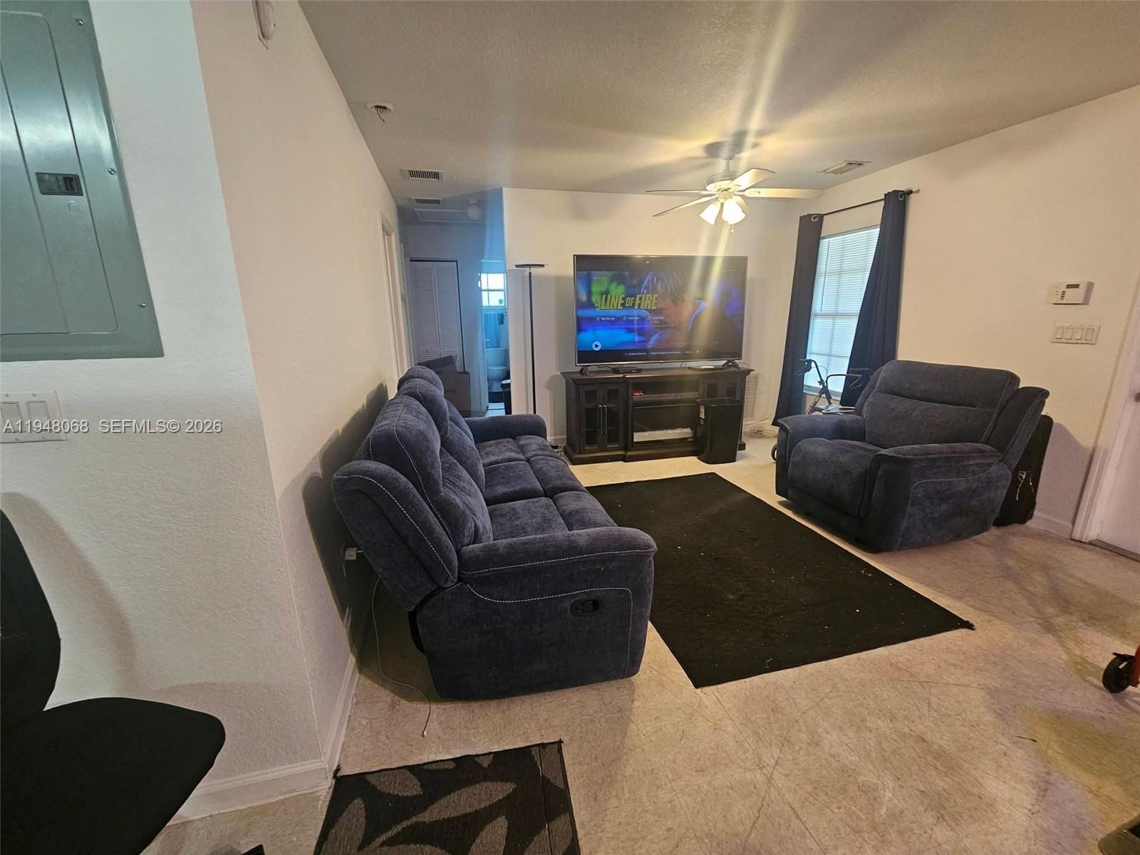 2145 Northwest 68th Terrace Miami, FL 33147 - Photo 8 of 12 a living room with furniture and a flat screen tv