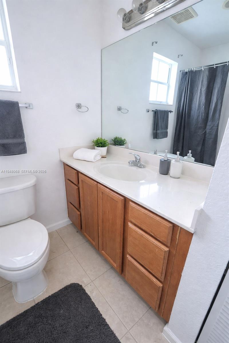 2145 Northwest 68th Terrace Miami, FL 33147 - Photo 10 of 12 a bathroom with a granite countertop sink toilet and mirror