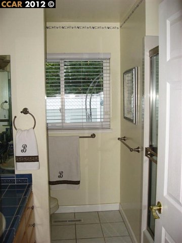 55 Gate Road Walnut Creek, CA 94598 - Photo 13 of 22 a bathroom with a granite countertop sink a mirror and a shower