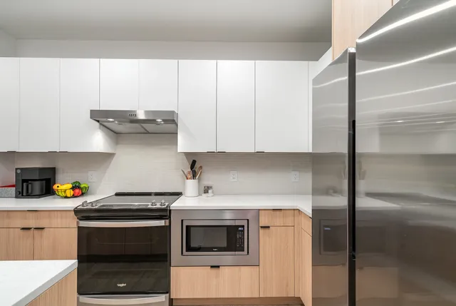 a kitchen that has a lot of cabinets and wooden floor