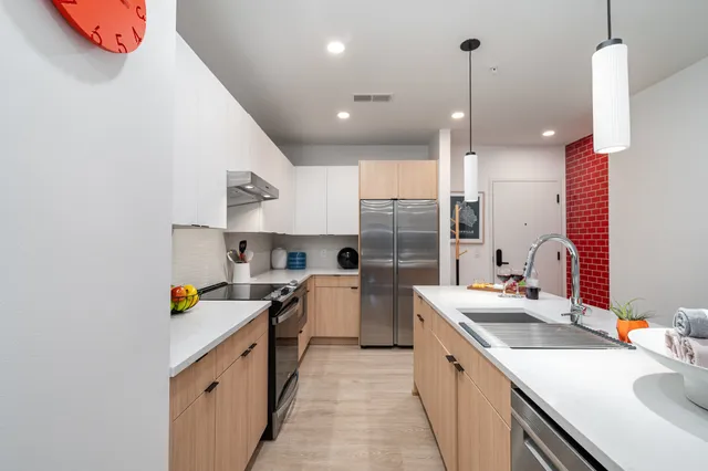 a kitchen with a sink a counter top space stainless steel appliances and cabinets