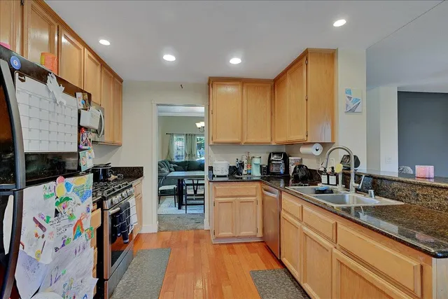 a kitchen with stainless steel appliances granite countertop a stove a sink and a refrigerator