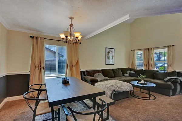 a living room with furniture a chandelier and a window