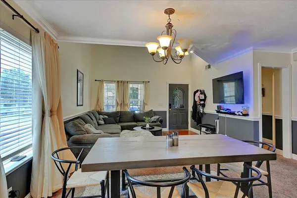a view of a dining room with furniture and a chandelier