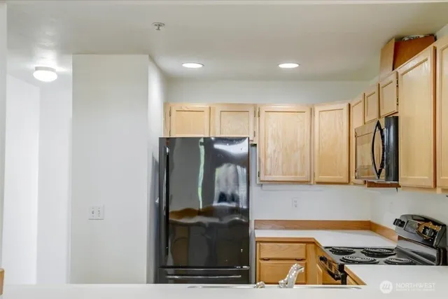 a kitchen with stainless steel appliances granite countertop a sink a stove and a microwave
