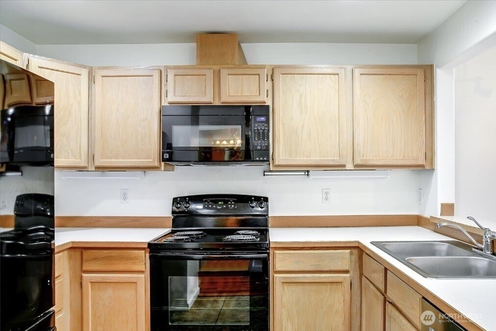 8515 244th Street Southwest, Unit A2 Edmonds, WA 98026 - Photo 13 of 22 a kitchen with stainless steel appliances granite countertop a sink a stove and a microwave