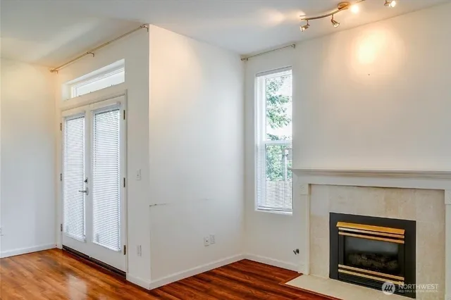 a view of empty room with a fireplace and wooden floor