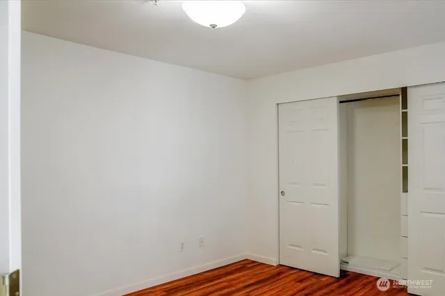 a view of bedroom with wooden floor and closet