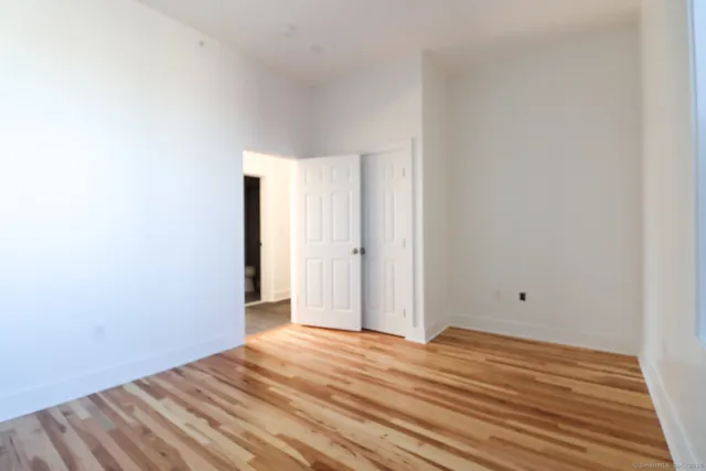 a view of empty room with wooden floor