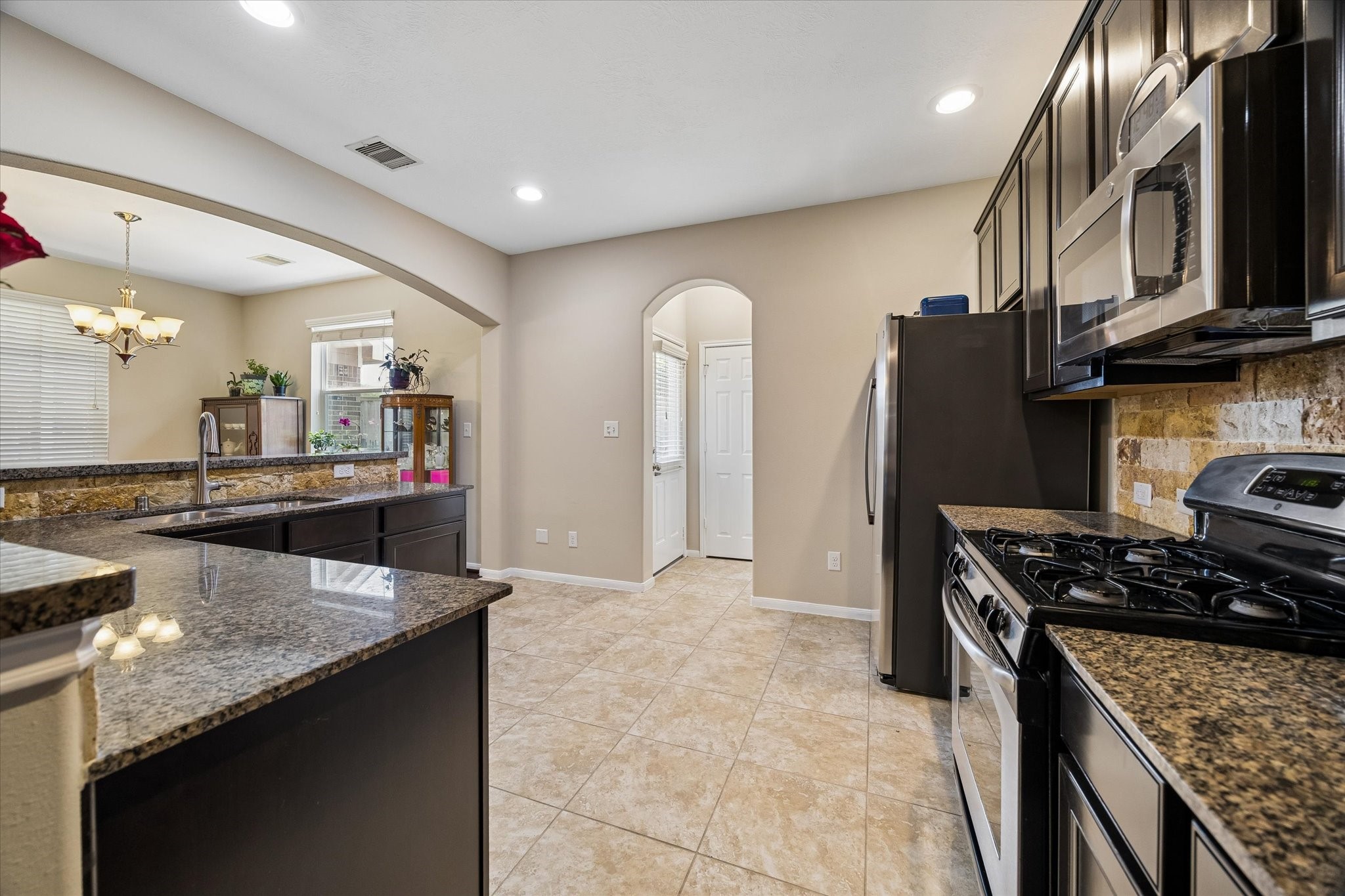 8433 Sunset Loch Drive Spring, TX 77379 - Photo 13 of 25 a kitchen with stainless steel appliances granite countertop a sink stove and refrigerator