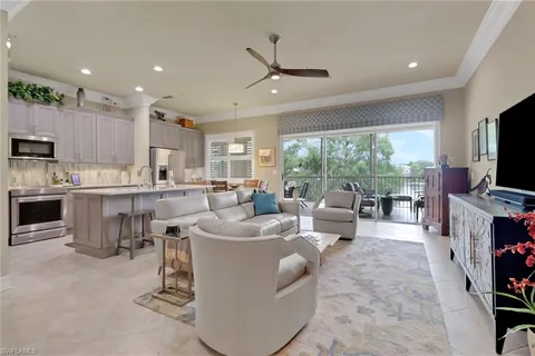 a living room with furniture a flat screen tv and a large window