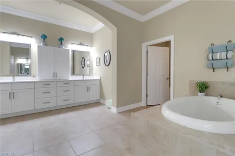 a spacious bathroom with a tub sink and mirror