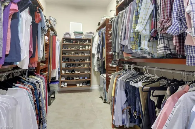 a view of walk in closet with clothes and shoes