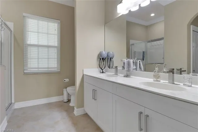 a bathroom with a double vanity sink a toilet and a window