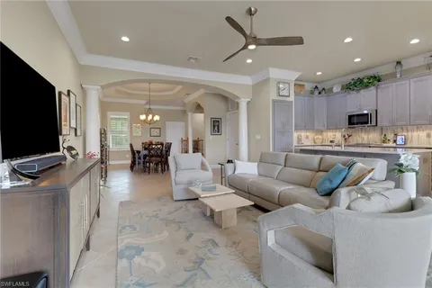 a living room with furniture kitchen view and a flat screen tv