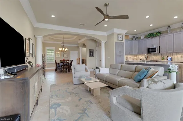 a living room with furniture kitchen view and a flat screen tv