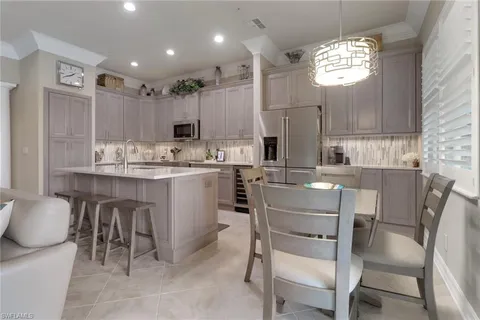 a kitchen with a dining table chairs cabinets and stainless steel appliances
