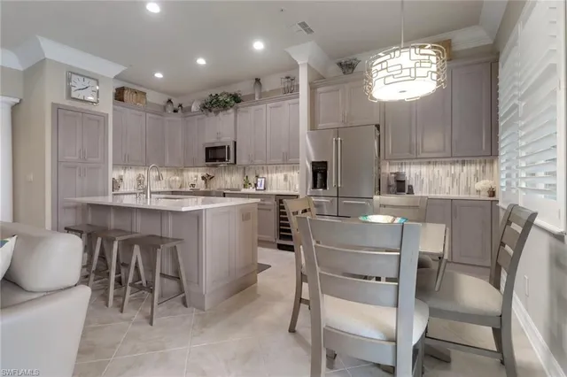 a kitchen with a dining table chairs cabinets and stainless steel appliances