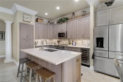 a kitchen with a sink a stove a refrigerator and white cabinets