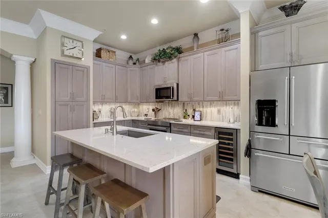 a kitchen with a sink a stove a refrigerator and white cabinets