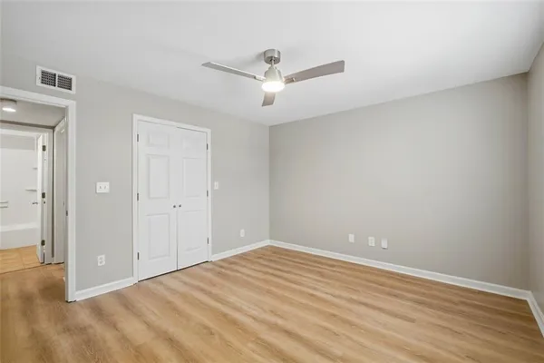 an empty room with wooden floor and windows