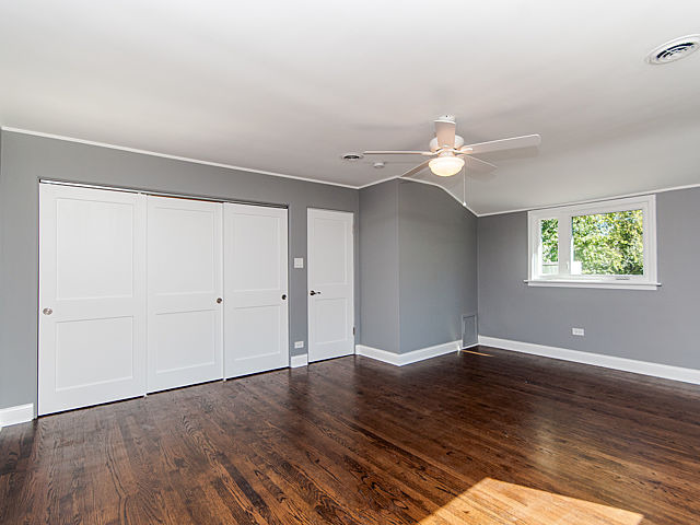 243 Longcommon Road Riverside, IL 60546 - Photo 17 of 25 an empty room with wooden floor chandelier fan and windows