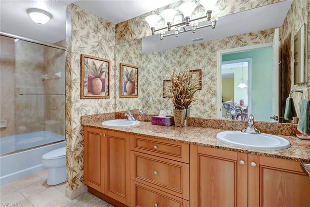 a bathroom with a double vanity sink mirror and shower