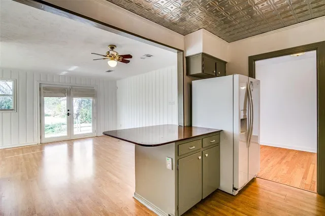 a kitchen with stainless steel appliances a refrigerator and a more cabinets