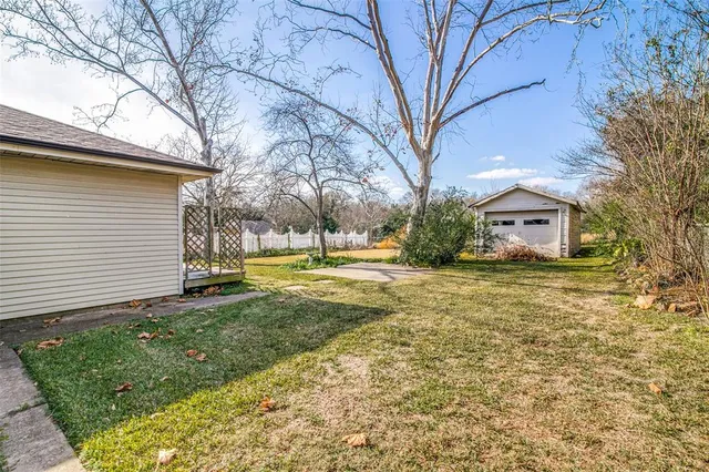a view of a house with backyard and tree